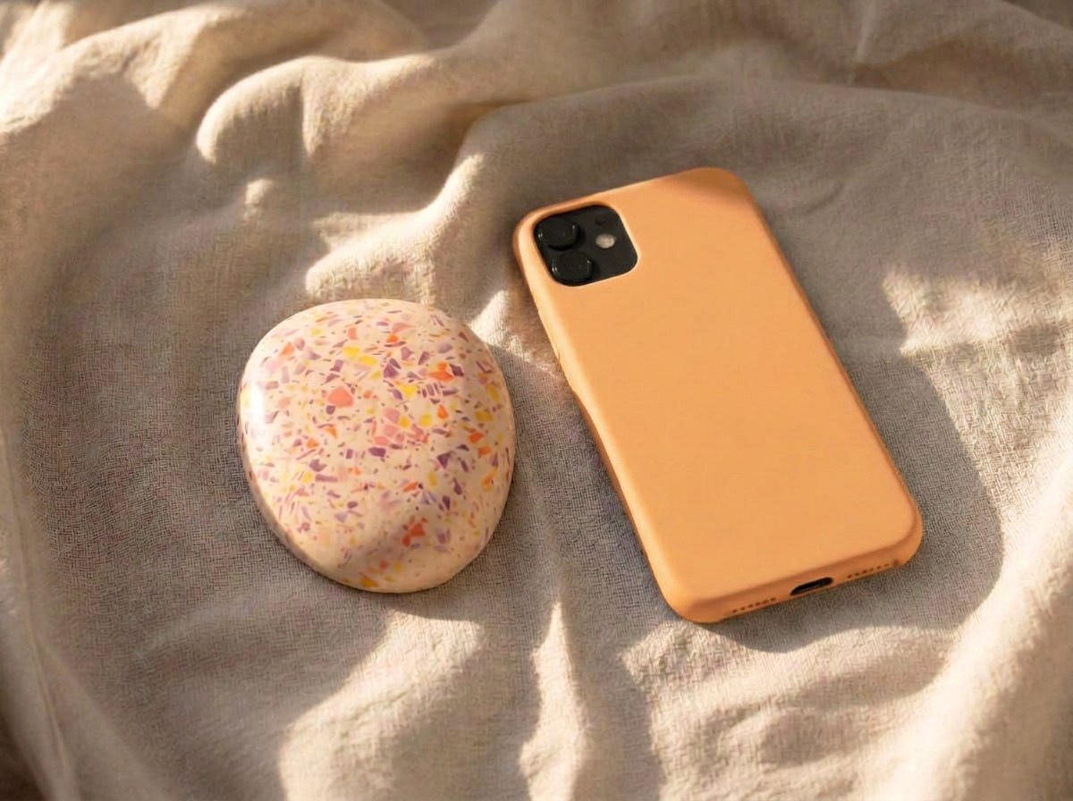 Ankerobjekt aus Keramik mit buntem Terrazzo neben einem abgelegten Smartphone auf Leinen